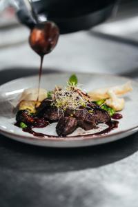 a plate of food with meat and vegetables on a table at Elements Hotel & Shops Curaçao in Willemstad