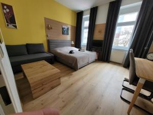 Habitación pequeña con cama y sofá en Leopoldauer Apartment, en Viena