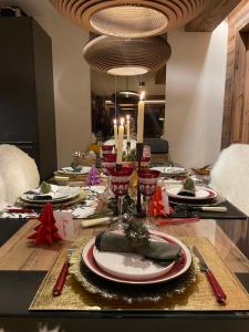 a dining room table with a christmas table setting with candles at Standing Megeve - 2 to 8 people - Mont d'Arbois in Megève