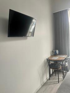 Habitación con mesa y TV en la pared. en Remény apartman en Szeged