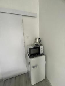 a microwave sitting on top of a refrigerator at Remény apartman in Szeged