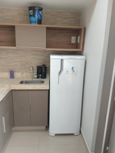 um frigorífico branco numa cozinha com um lavatório em Park Veredas Flat Service em Rio Quente