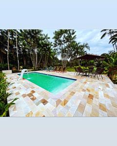 a swimming pool with a table and chairs in a yard at Vila Noah Pousada in Paraty