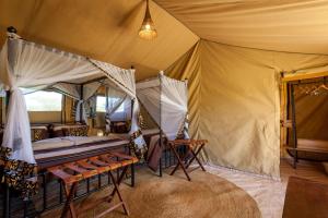 a bedroom with a bed in a tent at Gnu Mara River Camp in Serengeti