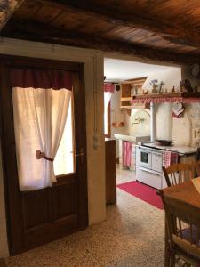 una cocina con una puerta que da a una cocina con fogones en Casa Stayerat-holiday home Segusino-Valdobbiadene, en Sequsino