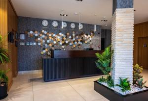 an office lobby with a reception desk and plants at Görükle Alpaş Yaşam Hotel in Bursa