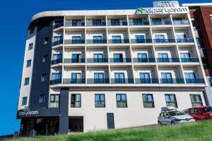 a white building with a car parked in front of it at Görükle Alpaş Yaşam Hotel in Bursa