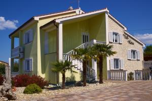 a house with palm trees in front of it at Matteo in Malinska