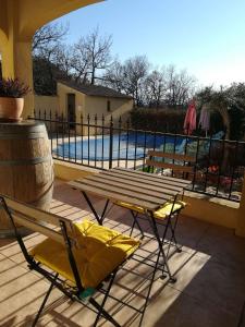 una mesa de picnic y sillas en un patio con piscina en Chez TATA en Régusse