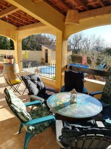 a patio with a table and chairs on a porch at Chez TATA in Régusse