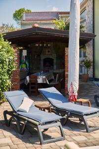 two lounge chairs and an umbrella on a patio at Matteo in Malinska +3 photos