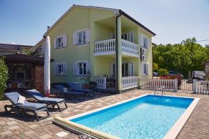 a house with a swimming pool in front of a house at Matteo in Malinska