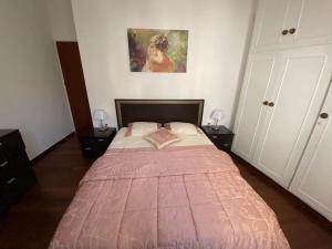 1 dormitorio con 1 cama grande con manta rosa en Irene's Guest Home, en Chalkida