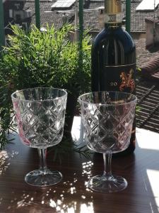 zwei Gläser auf einem Tisch neben einer Flasche Wein in der Unterkunft BRIC NEST il luogo ideale per la tua vacanza. in Florenz