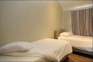 Cette chambre comprend 2 lits et une fenêtre. dans l'établissement Villa 2 chambres au bord du lac de l'Eau d'Heure, à Froidchapelle