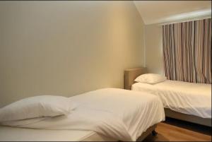 a hotel room with two beds and a window at Villa 2 chambres au bord du lac de l'Eau d'Heure in Froid-Chapelle
