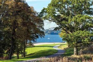 a golf course with a lake and a boat in the water at Villa 2 chambres au bord du lac de l'Eau d'Heure in Froid-Chapelle
