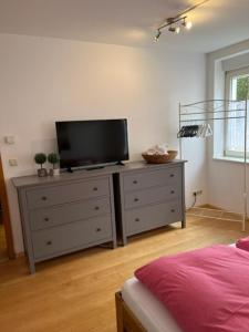 a bedroom with a dresser with a television on it at Allgäutraum Ferienwohnung Nr 4 in Kempten