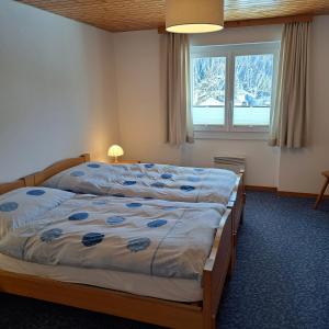 1 dormitorio con 2 camas y ventana en Chalet Waldrand, en Inden