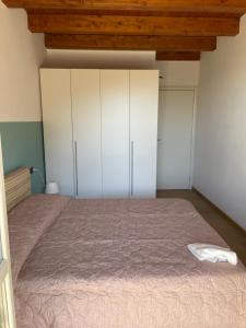 een slaapkamer met witte kasten en een groot bed bij Sun Lake Iseo apartment in Sale Marasino