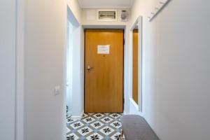 un couloir avec une porte en bois et du carrelage. dans l'établissement Downtown Modern - 2BR Apartment, à Bucarest
