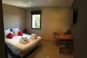 a bedroom with a bed and a desk with a laptop at Belle villa avec piscine intérieure et piscine extérieure Gite Les Aiguiers in Grignan
