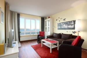 uma sala de estar com um sofá e uma mesa em Strandhotel 5 em Laboe