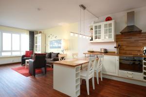 uma cozinha e sala de estar com mesa e cadeiras em Strandhotel 5 em Laboe