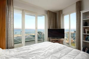 - une chambre avec un lit et une grande fenêtre dans l'établissement Strandhotel 17, à Laboe