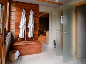 a bathroom with a walk in shower with a wooden wall at Spa Oasis Samanta in Ludbreg