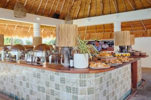 a buffet at a resort with food on a counter at Soho Beach House Canouan in Canouan