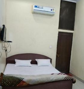 a bedroom with a bed with a air conditioner on the wall at Hotel Hansa Palace by WB Inn in Kānpur