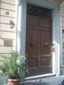 a wooden door on a house with a potted plant at Hotel Bolognese in Rome