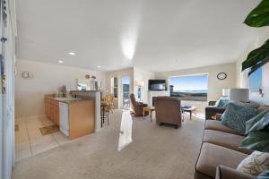 a living room with a couch and a kitchen with a table at Daydreaming in Westport