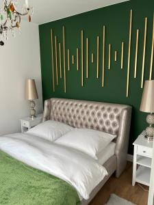 a bedroom with a bed with a green accent wall at Apartament Złoty 3 in Zblewo