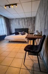 a bedroom with a bed and a desk and a table at Hotel De Schacht in Genk
