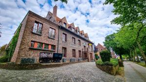 a large brick building on a cobblestone street at Hotel De Schacht in Genk