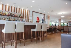 a bar in a restaurant with white bar stools at Exuberante hotel na Vila Olimpia in São Paulo