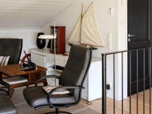 - un salon avec une chaise et un voilier sur le mur dans l'établissement Holiday home Bua II, à Bua