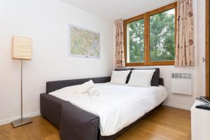 a large bed in a room with a window at Apartment Chamois Blanc 2 in Chamonix-Mont-Blanc