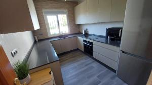 una cocina con armarios blancos y electrodomésticos negros en Villa Mondriana, en Mondrón