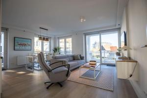 a living room with a couch and a table at Home Away, Light and Bright in Cadzand