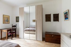 a bedroom with a mirror door with a bed and a desk at Casa con giardino a Borgo Panigale in Bologna