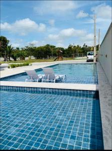 a swimming pool with two lounge chairs next to it at Apartamento nos Lencois Confort in Barreirinhas
