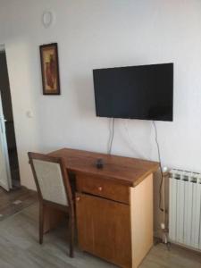a desk with a chair and a television on a wall at VILLA SIMKA in Kočani