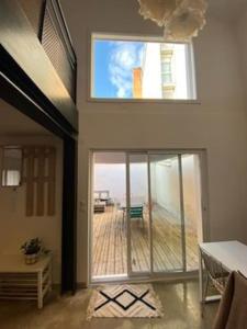 Cette chambre dispose d'une grande porte coulissante en verre avec une terrasse. dans l'établissement Maison duplex avec terrasse proche de la gare SNCF, à Clermont-Ferrand