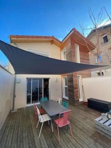 a patio with a table and chairs on a deck at Maison duplex avec terrasse proche de la gare SNCF in Clermont-Ferrand