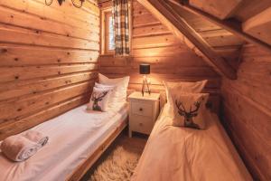 a bedroom with two beds in a log cabin at Poziomkowa Chata in Szczyrk