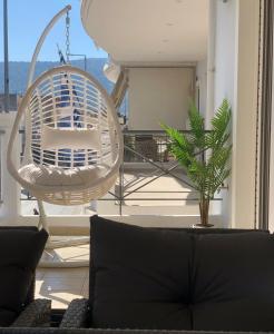 a living room with a white chair and a plant at Escape Luxury Apartment in Nafplio