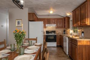 uma cozinha com uma mesa e um frigorífico branco em The Lodge at Moosehead Lake em Greenville
